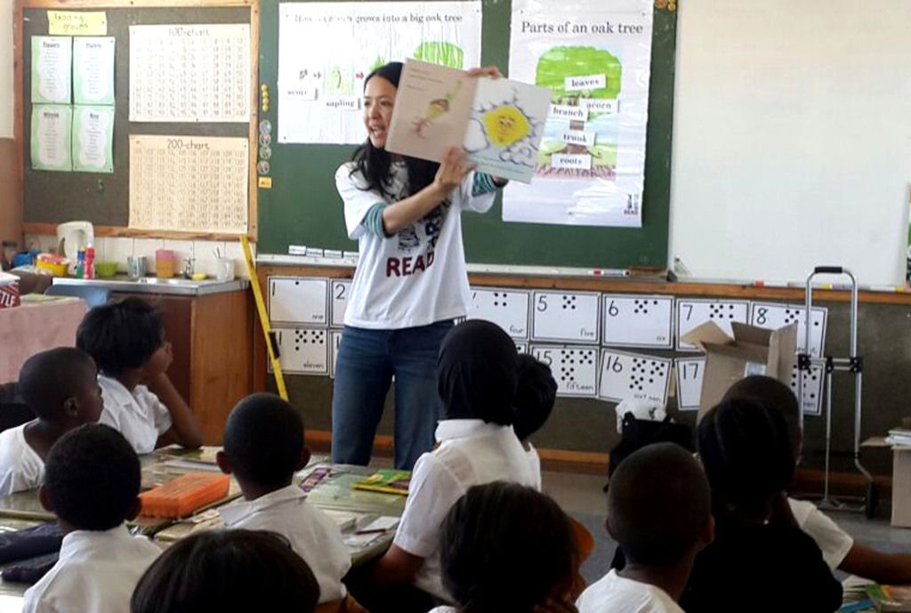 Taryn Lock reading a book to students at Westville